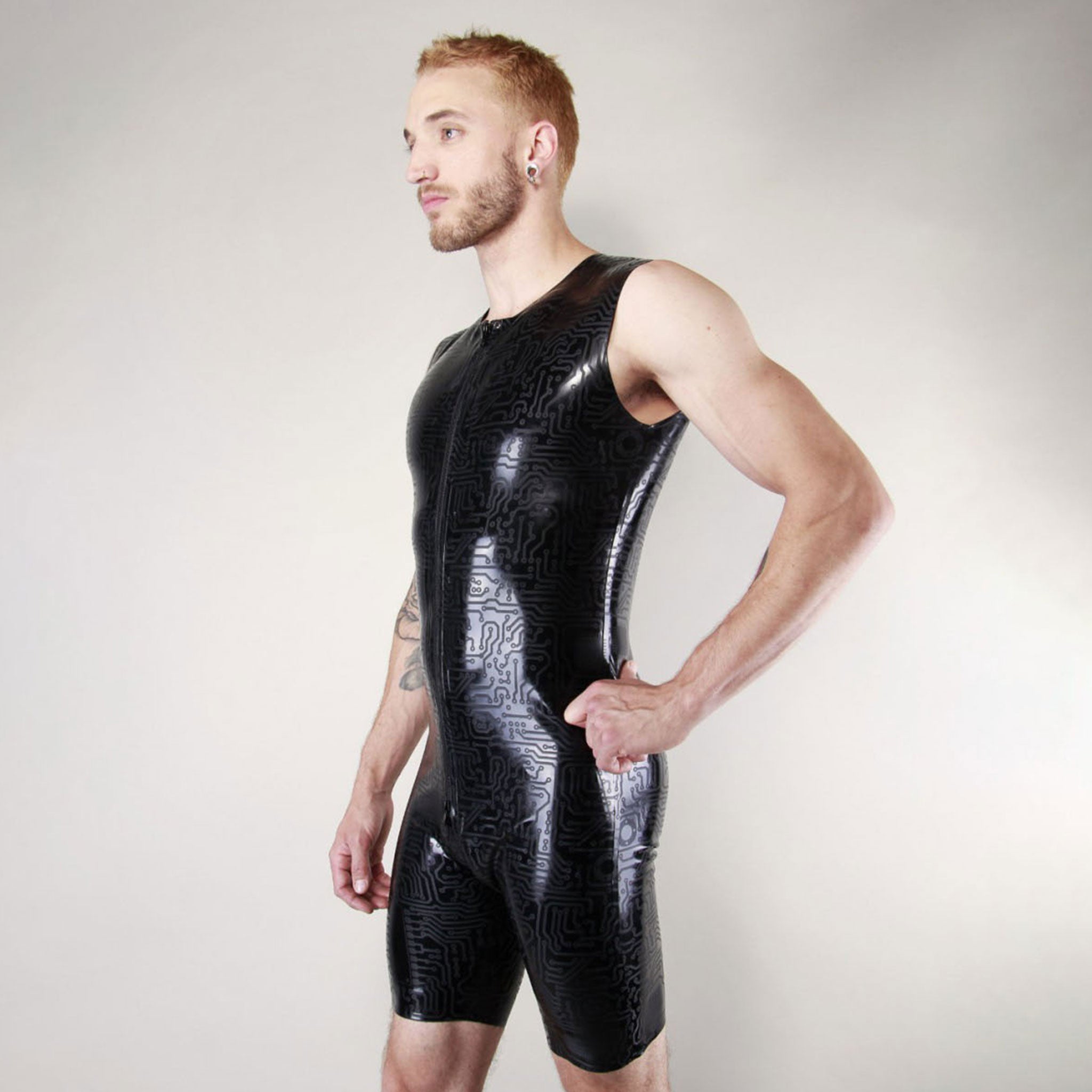 Latex rubber textured-latex etched-latex apparel one-piece surfsuit surf-suit short-leg sleeveless circuit-pattern circuit-print front-to-back through-zip thru-zip crotch-zip zipper circle-neckline surf surfer fetish fashion alt-fashion cyber bdsm bondage kink kinky kinkwear male masculine masc mens menswear guys dudes black